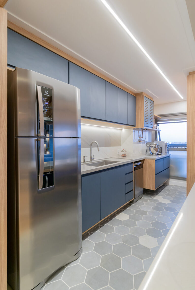 Maravilhosa cozinha planejada de alto padrão com armários aéreos e gabinete na cor azul petroleo